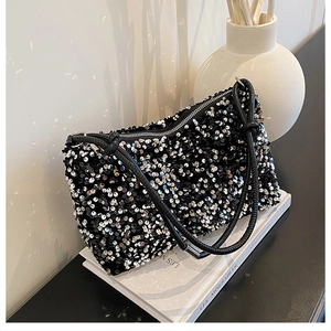 Detail view of a black sequin crossbody bag with silver glitter texture and chain strap