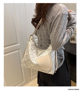 Dettaglio borsa tote argento metallizzato con motivi geometrici e tasca in pelle beige