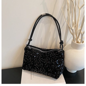 Detailed view of black sequin shoulder bag featuring silver zipper and knotted strap details