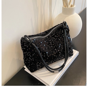 Close-up of black sequin crossbody bag texture with glossy shimmer and thin strap