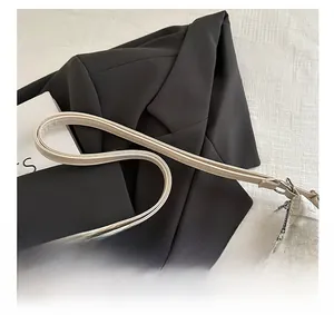 Dettaglio della trama in tela jacquard beige e tracolla in pelle fine della borsa