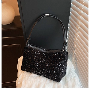 Close-up of black sequined shoulder bag with zip closure and elegant leather strap detail