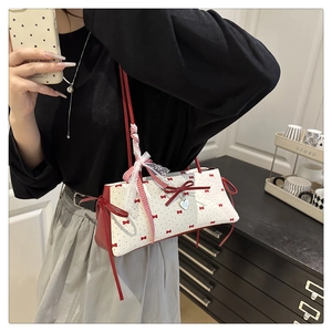 Détail du nœud rouge et dentelle blanche sur sac floral à pois pour femme
