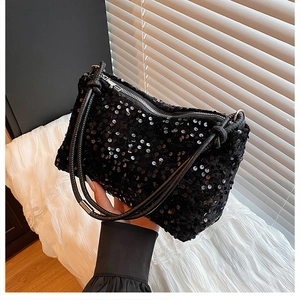Close-up of black sequin shoulder bag with silver zipper and sparkling fabric texture
