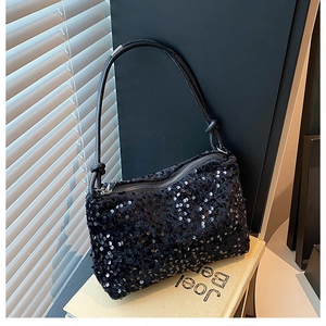 Close-up of black sequined crossbody bag with silver zipper and knotted shoulder strap