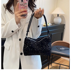 Detailed view of black sequin crossbody bag with chain strap and shiny metallic finish
