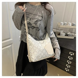 Detail view of jacquard pattern fabric and leather patch on off-white shoulder bag