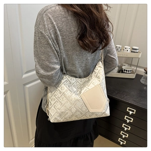 Dettaglio della borsa Hobo bianca con motivi floreali jacquard indossata sulla spalla