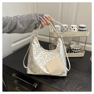 Macro view of silver jacquard pattern and beige pocket on a woman shoulder bag