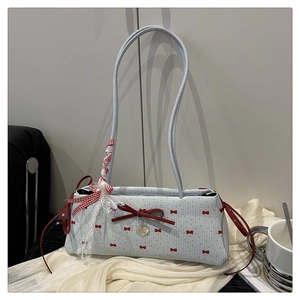 Détail du sac à bandoulière bleu clair avec nœud rouge et ruban en dentelle chic