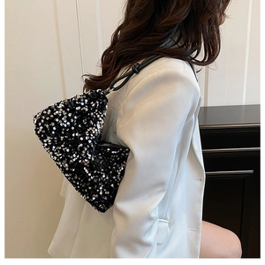 Detail of black sequined shoulder bag with metallic texture and sleek chain strap