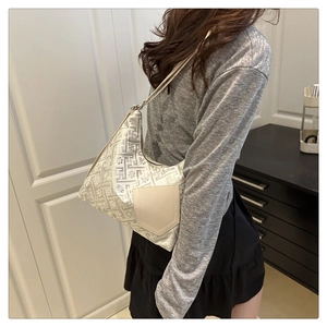 Borsa a spalla in jacquard argento con tasche beige indossata da una modella