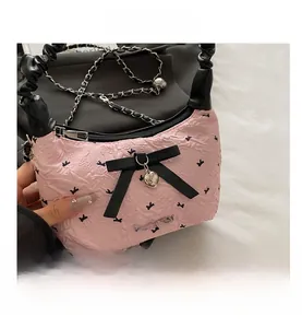 Detailed view of pink floral jacquard texture with black bow and heart pendant charm