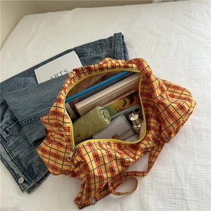 Grand sac cabas à carreaux chic montrant des livres et accessoires pour un usage quotidien