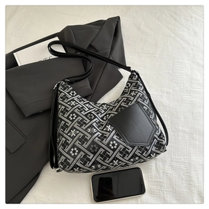 Detail of vintage black and white jacquard tote bag with leather pocket and shoulder strap