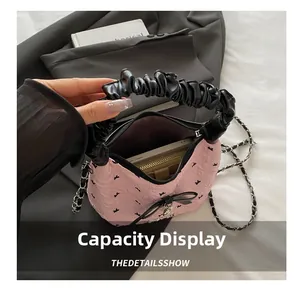 Pink fabric handbag detail showing internal capacity for phone and wallet with metal chain