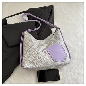 Detailed view of purple jacquard embroidery pattern and leather pocket on shoulder bag