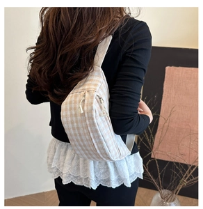 Detail der schicken beige karierten Brusttasche mit Doppelreißverschluss und Umhängeriemen