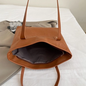 Grand sac cabas en cuir marron avec motifs embossés pour femme dans un décor lifestyle