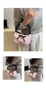 Detail of pink ballet-style bag featuring black bows and bunny pattern texture