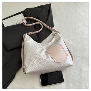 Detail view of white jacquard hobo bag with pink pocket and adjustable shoulder strap