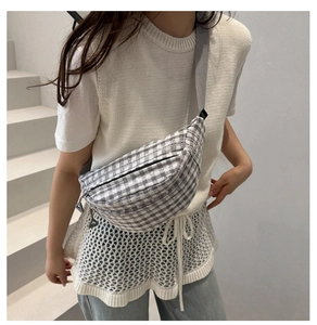 Detail of adjustable gray wide strap and zip closure on gingham canvas crossbody bag