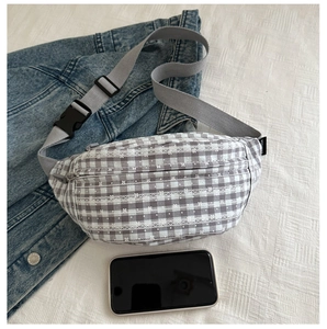 Detail of checkered waist bag with white lace trim, wide grey strap and plastic buckle