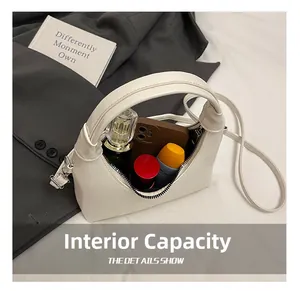 Internal capacity of white leather bag showing space for phone and perfume