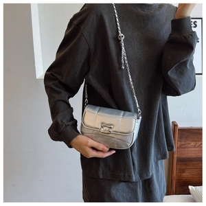 Détail du sac argenté matelassé avec boucle G et chaîne métallique ajustable
