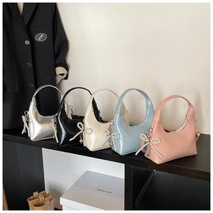 Five shiny hobo bags in silver, black, white, blue and pink with pearl bow charms