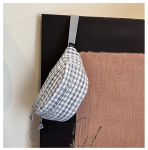 Detail view of the grey and white gingham canvas crossbody bag with dual zippers and woven strap