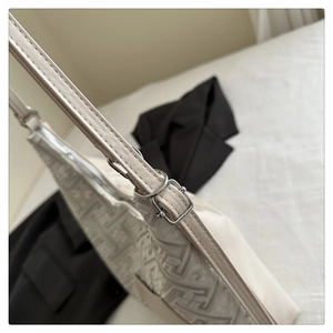 Detailed view of silver D-ring buckle and embroidery texture on the shoulder bag
