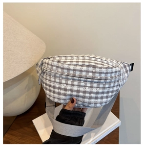 Detail der grauen Karo-Gürteltasche aus Canvas mit Blumenstickerei und verstellbarem Gurt