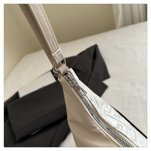 Detail shot of the beige leather handbag featuring woven patterns and a silver zipper