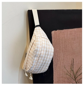Detail der karierten Canvas-Gürteltasche mit weißen Blumenmustern und Doppelreißverschluss