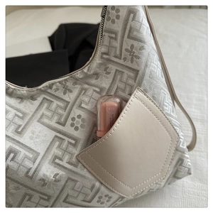 Detail of Chinese style jacquard fabric bag showing plum blossom pattern and side pocket