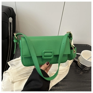 Detail of bright green pebble leather flap bag with gold chain mini coin purse attachment