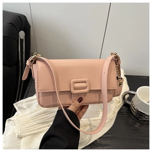 Detailed view of pink lychee leather baguette bag with magnetic buckle and chain strap