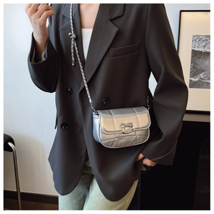 Détail du sac bandoulière argenté matelassé avec chaîne et boucle en forme de U