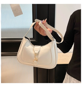 Dettaglio della borsa hobo in pelle bianca con fibbia a pistone dorata e design curvo