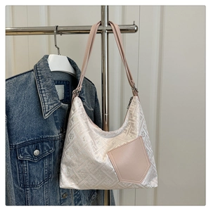 Detail of hobo shoulder bag with floral jacquard fabric and pink leather pocket detail
