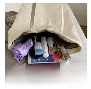 Detailed interior of the beige canvas tote bag showing its large storage capacity