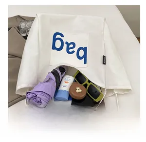 Interior view of large canvas tote bag showing umbrella, sunglasses, and books