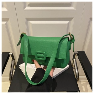 Detail of green leather shoulder bag with lychee texture and gold metal hardware link