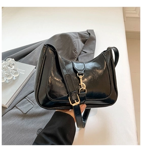 Dettaglio della borsa hobo nera lucida con fibbia in metallo dorato e zip scorrevole