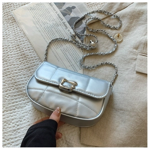 Gros plan du sac en cuir matelassé argenté avec chaîne et boucle de réglage sphérique