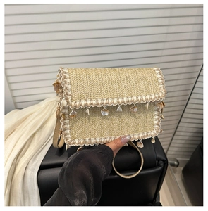 Detail of bohemian straw bag featuring shell charms and white lace trim texture