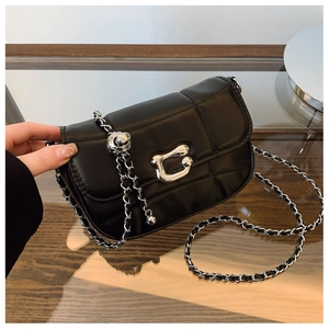 Détail du sac à chaîne matelassé noir avec boucle métallique argentée sur verre