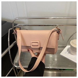 Detail of pink lychee leather baguette bag featuring a matching leather buckle closure