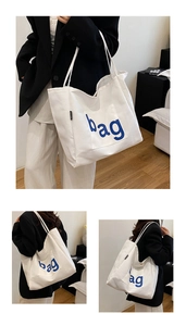 Detail showing high-capacity white canvas tote bag with blue bag print and side label